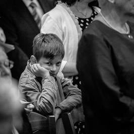 photographe de mariage garçon boude dans l'église ennui à Dijon