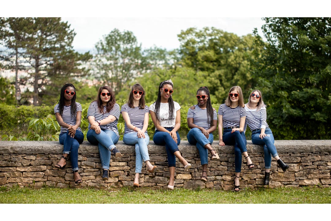Photographe EVJF à Dijon avec filles portant des lunettes et assises sur un mur en pierre